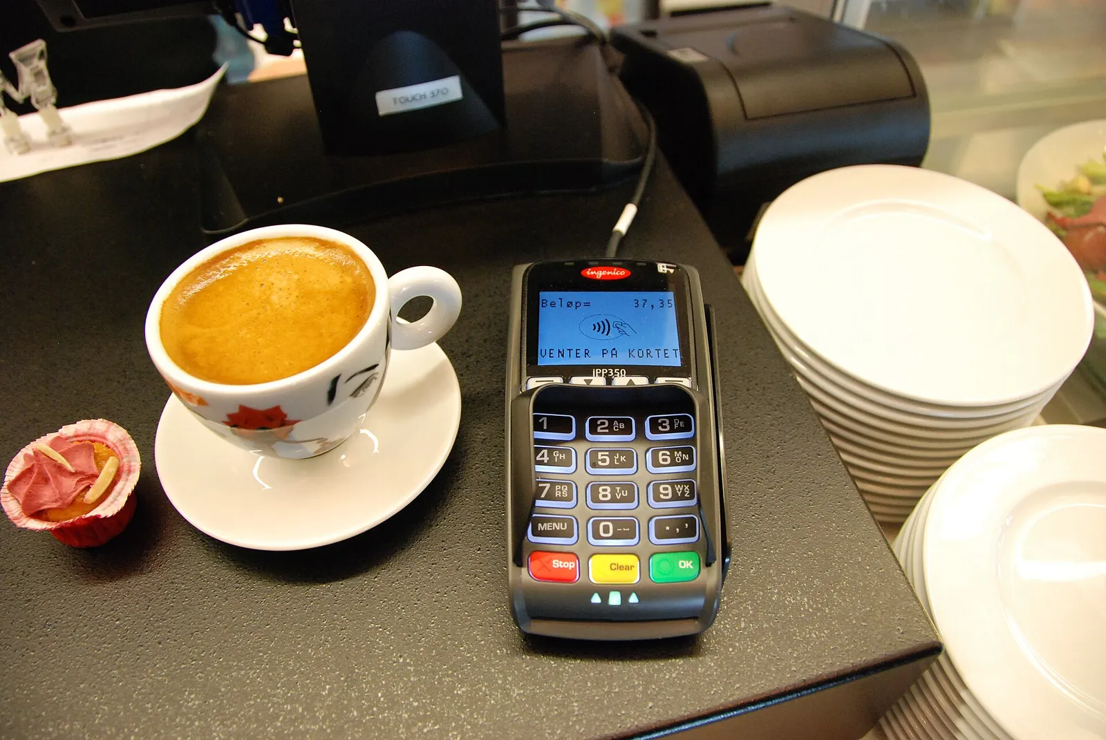 Una persona paga acercando el móvil a un terminal de pago
