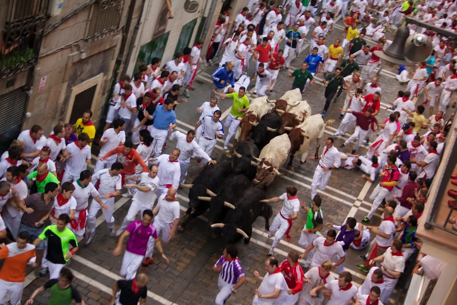 Corredores y toros durante un encierro de San Fermín en la calle Estafeta de Pamplona