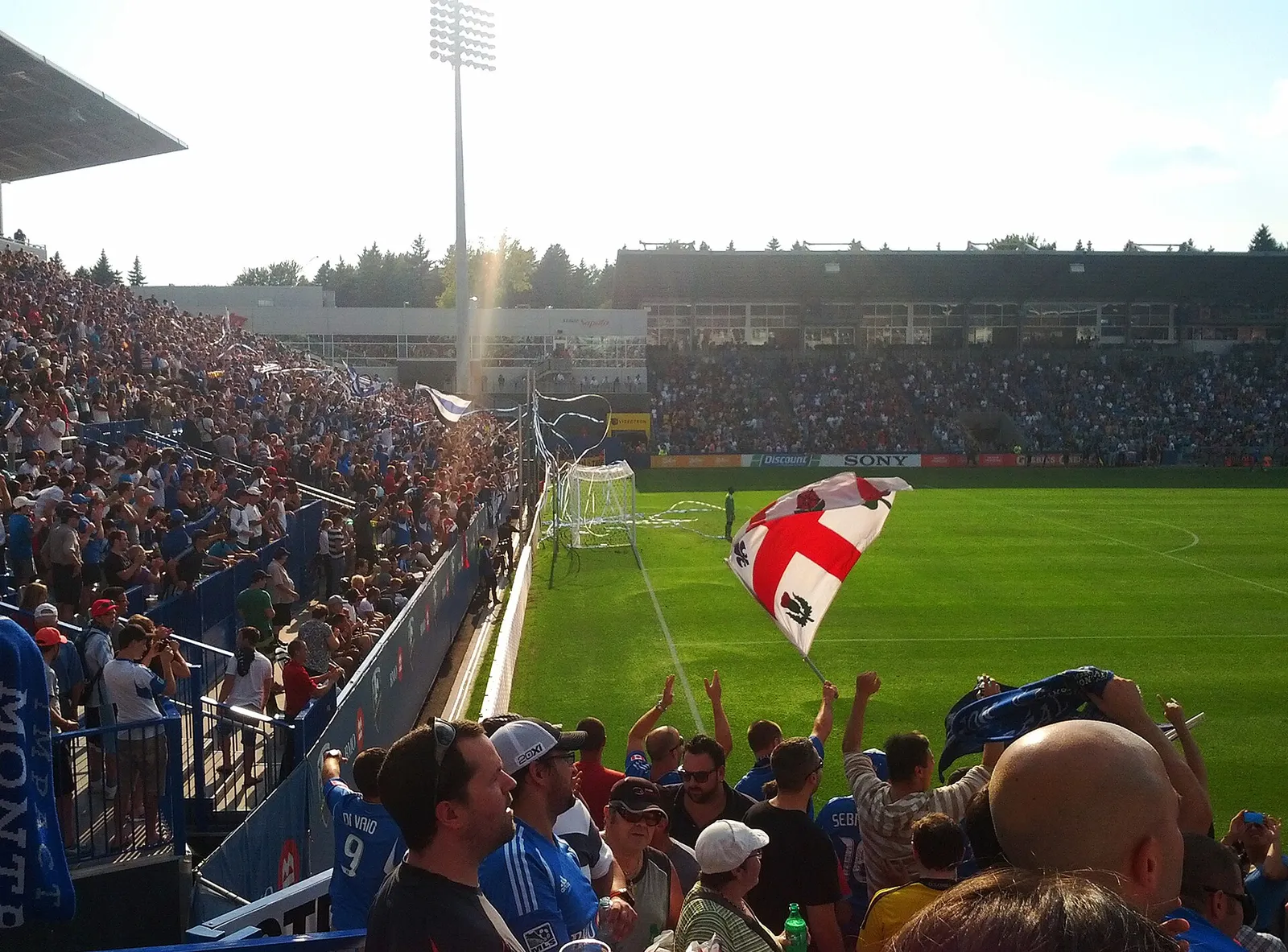 Aficionados al fútbol celebrando con una bandera (imagen ilustrativa)