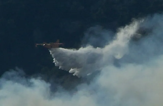 Un hidroavión de extinción descarga agua sobre un incendio forestal