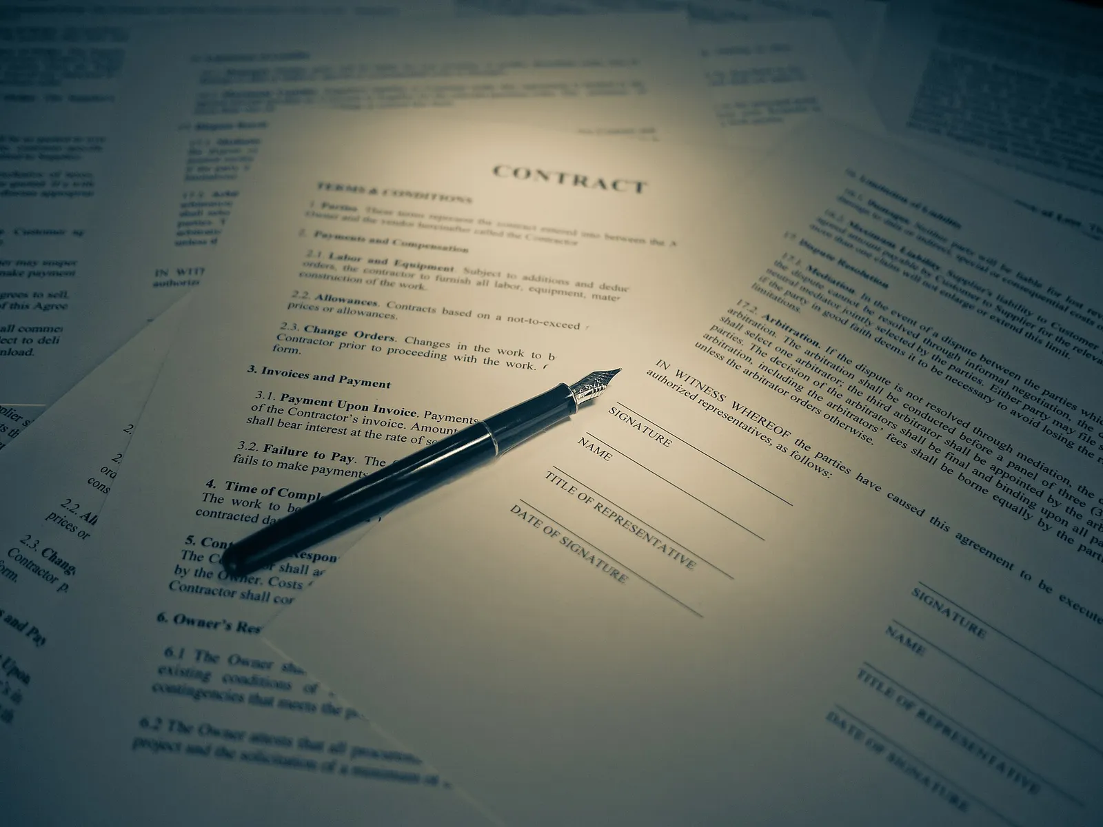 Una persona firma un documento legal sobre una mesa