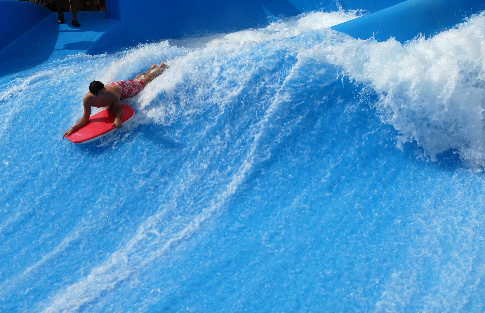 Un surfista cabalga una ola en una piscina de olas artificiales