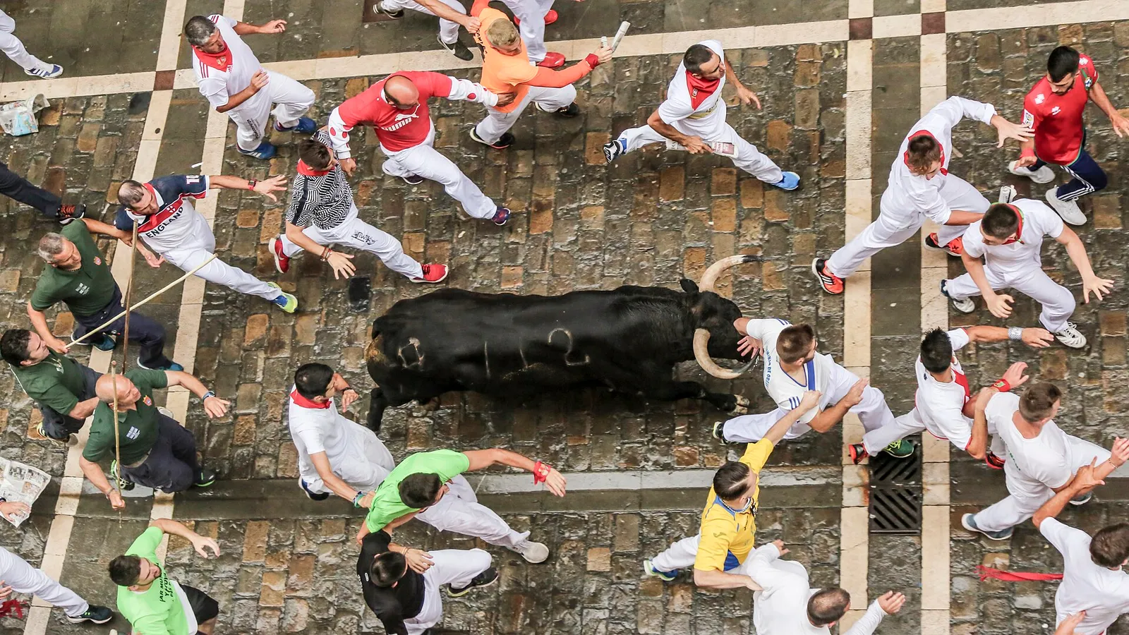 Mozos corren junto a un toro durante un encierro de San Fermín en Pamplona