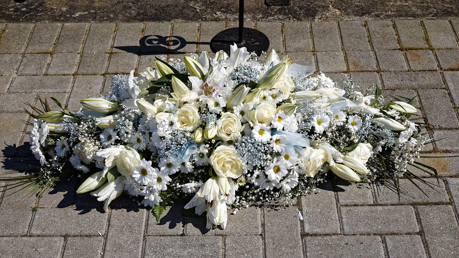 Corona de flores blancas en homenaje (imagen de archivo)