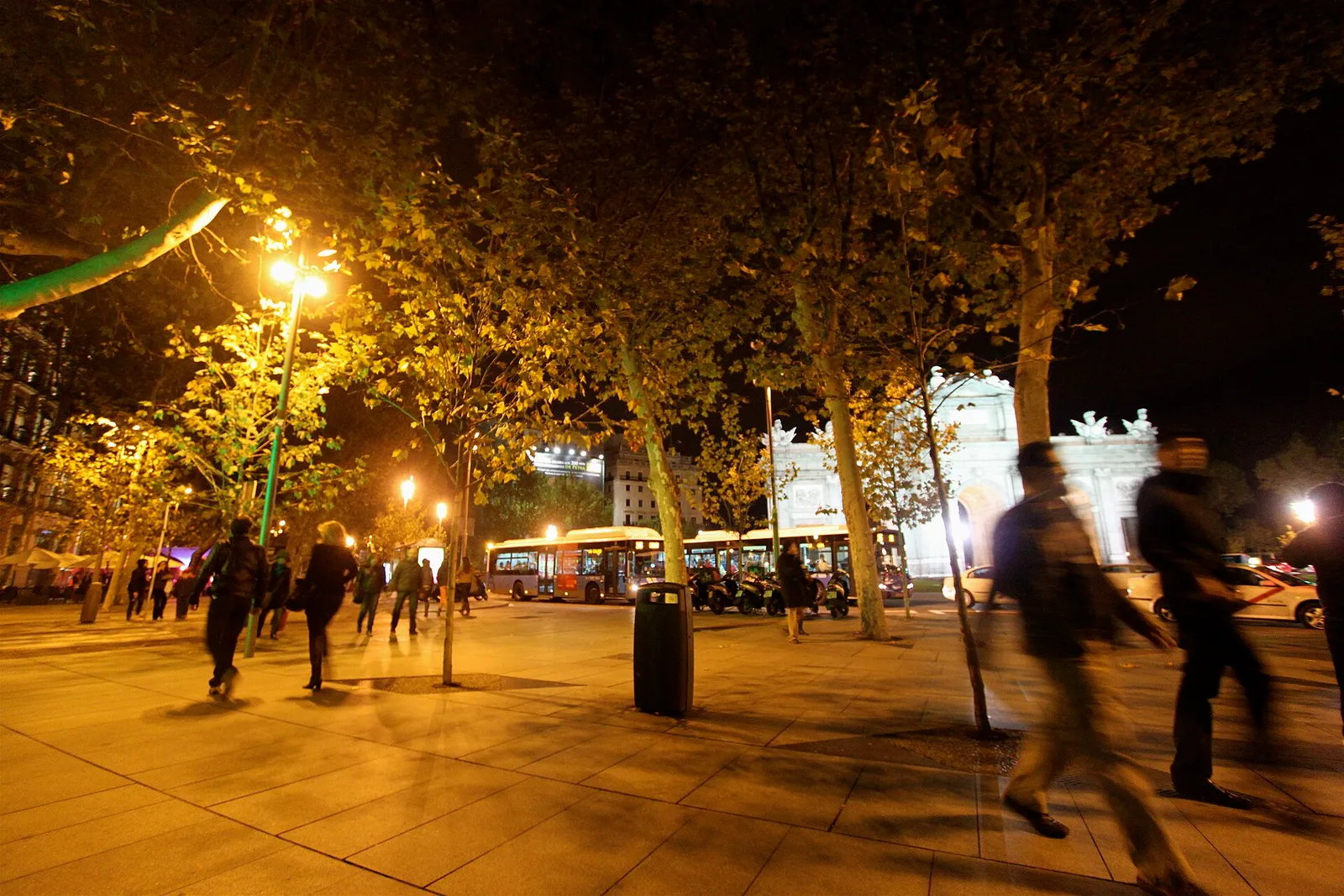 Peatones caminando junto a la Puerta de Alcalá, en Madrid